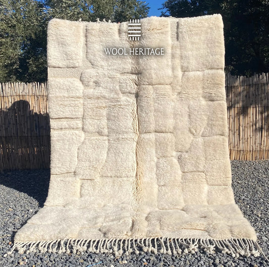 IGHREM hand-knotted ivory Moroccan wool rug displayed outdoors in a full front view