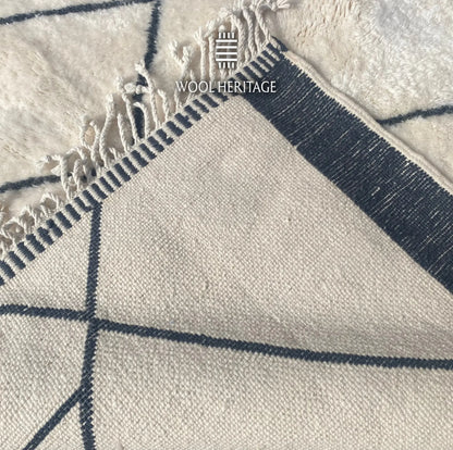 Back of ADRAR Beni Mrirt rug showing its woven construction, charcoal border, geometric linework, and fringe finish