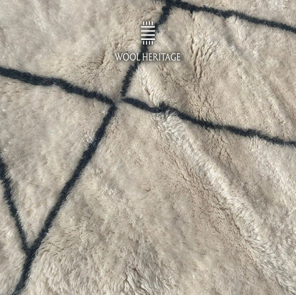 Detailed view of ADRAR rug showing intersecting charcoal mountain-like lines against the soft ivory wool pile