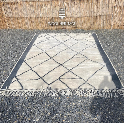 ADRAR Beni Mrirt rug laid flat, showing its complete charcoal mountain-like geometry across a warm ivory field