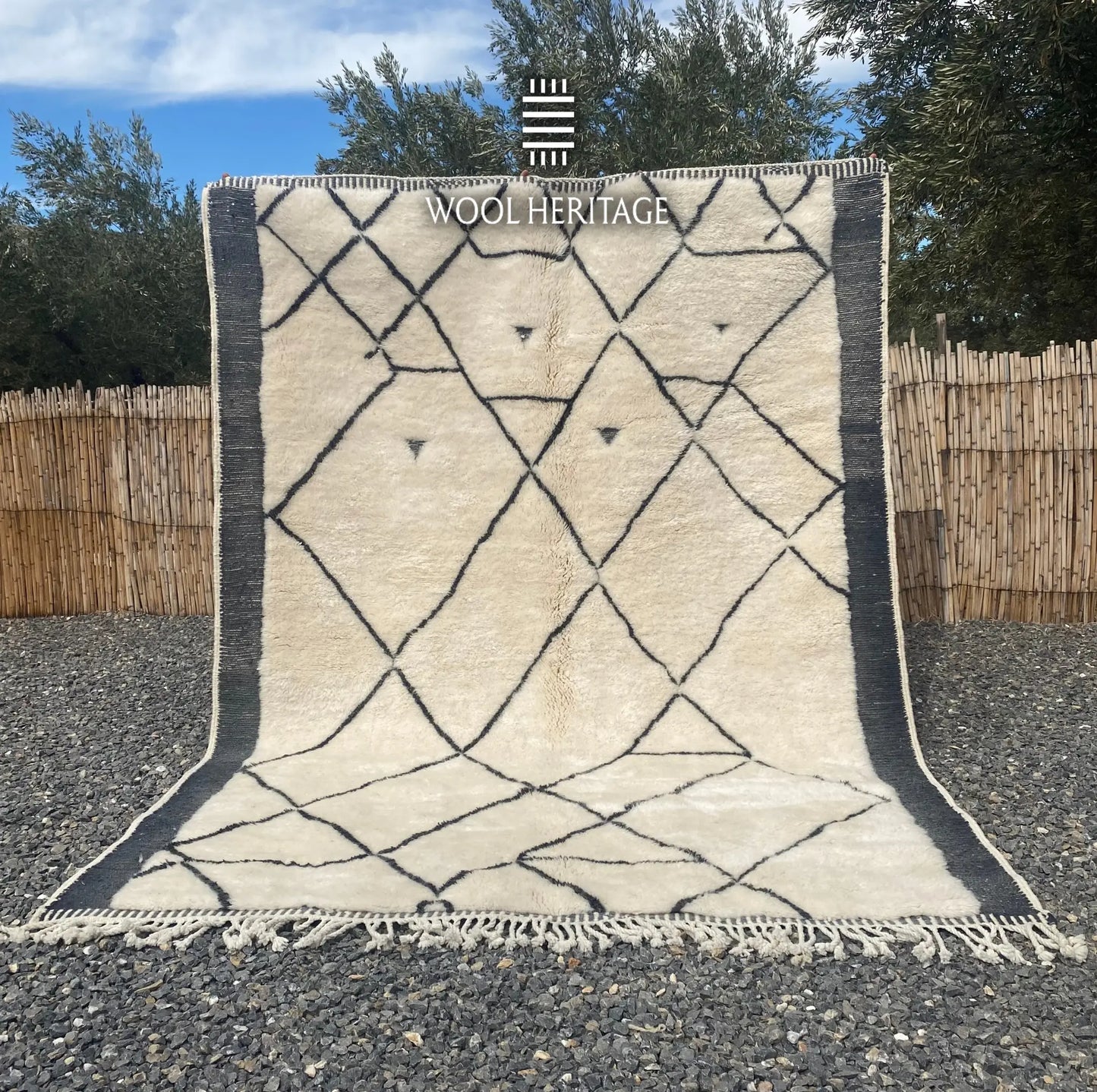 ADRAR hand-knotted ivory and charcoal Moroccan wool rug displayed outdoors in a full front view