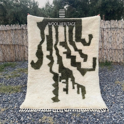 AKNARI hand-knotted ivory and olive Moroccan wool rug displayed outdoors in a full front view