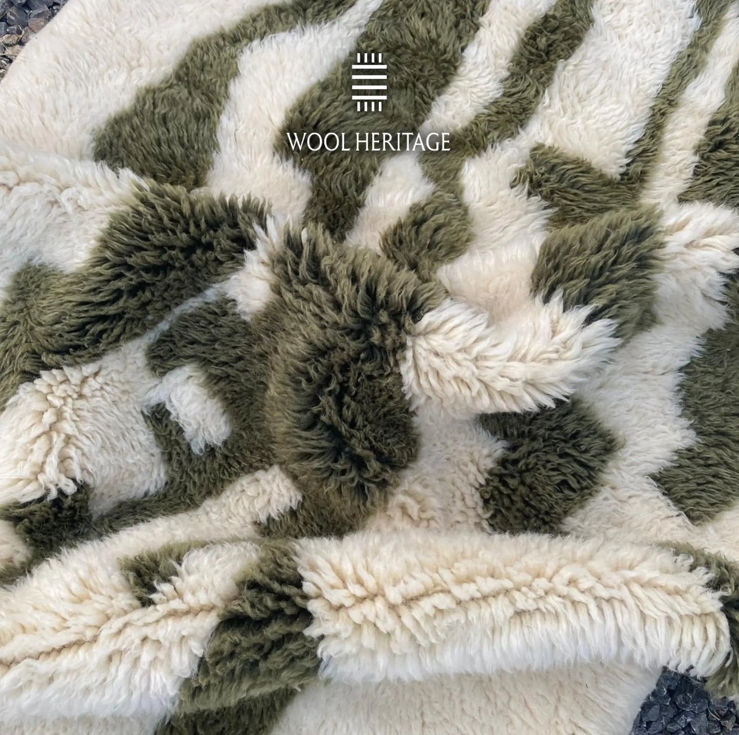 Detailed view of AKNARI rug showing raised dark olive cactus forms against the soft ivory wool field