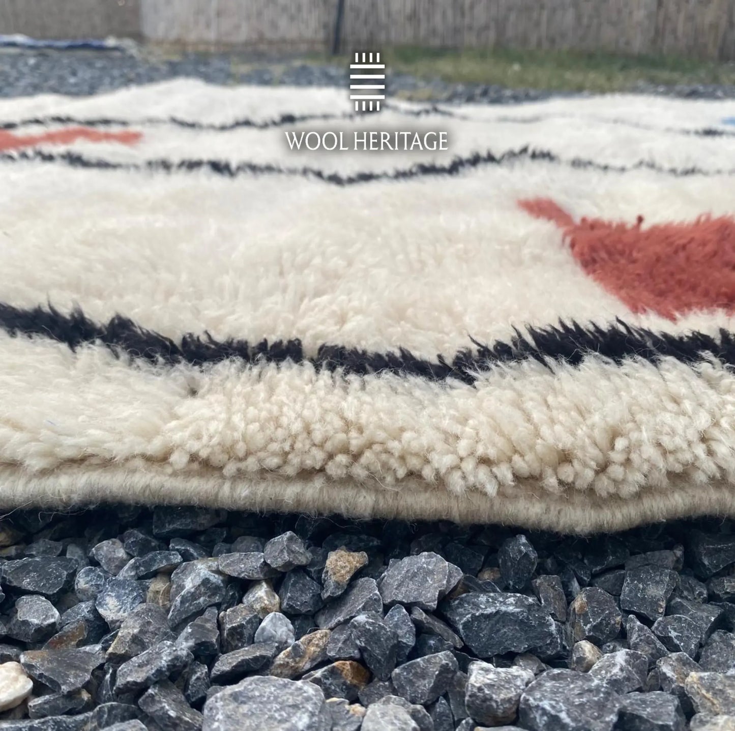 Close-up of AMARG rug showing its soft ivory Moroccan wool pile, black linework, and finished edge