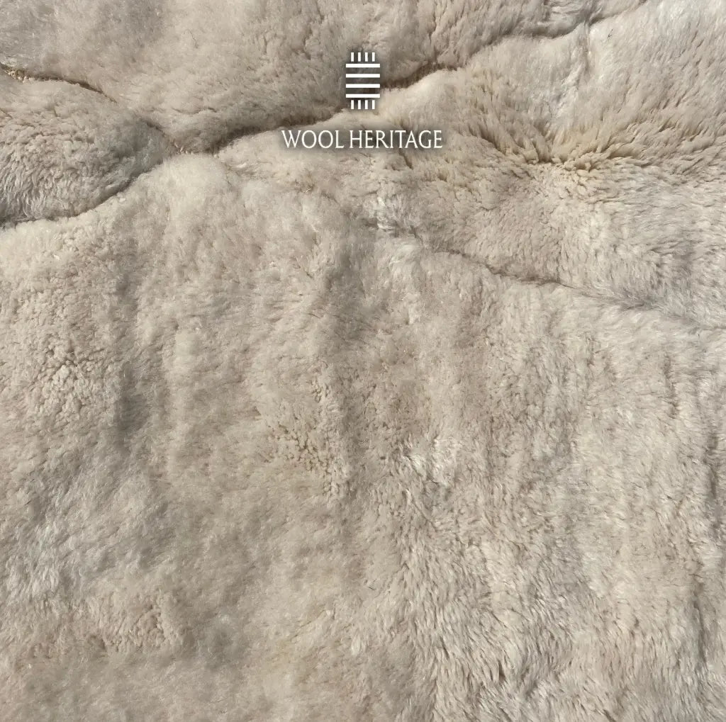 Close-up of AMLAL rug showing its soft ivory Moroccan wool pile and barely visible geometric texture