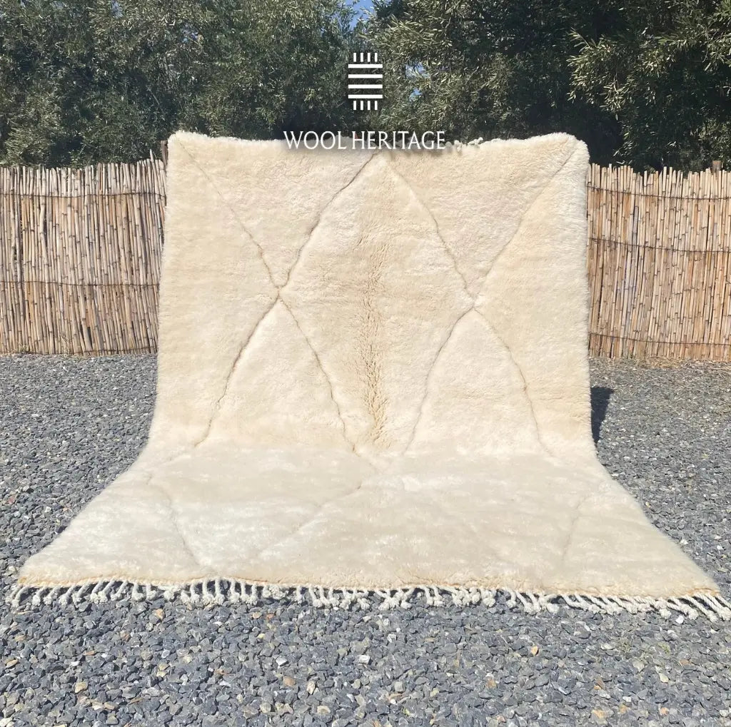 AMLAL hand-knotted white and ivory Moroccan wool rug displayed outdoors in a full front view with hand-finished fringe