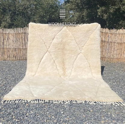 AMLAL hand-knotted white and ivory Moroccan wool rug displayed outdoors in a full front view with hand-finished fringe