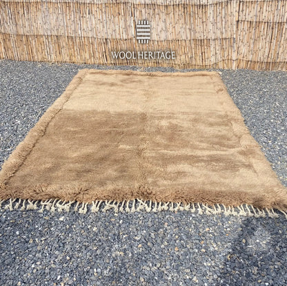 ASIREM camel Moroccan wool rug laid flat, showing its quiet field, border, and central line
