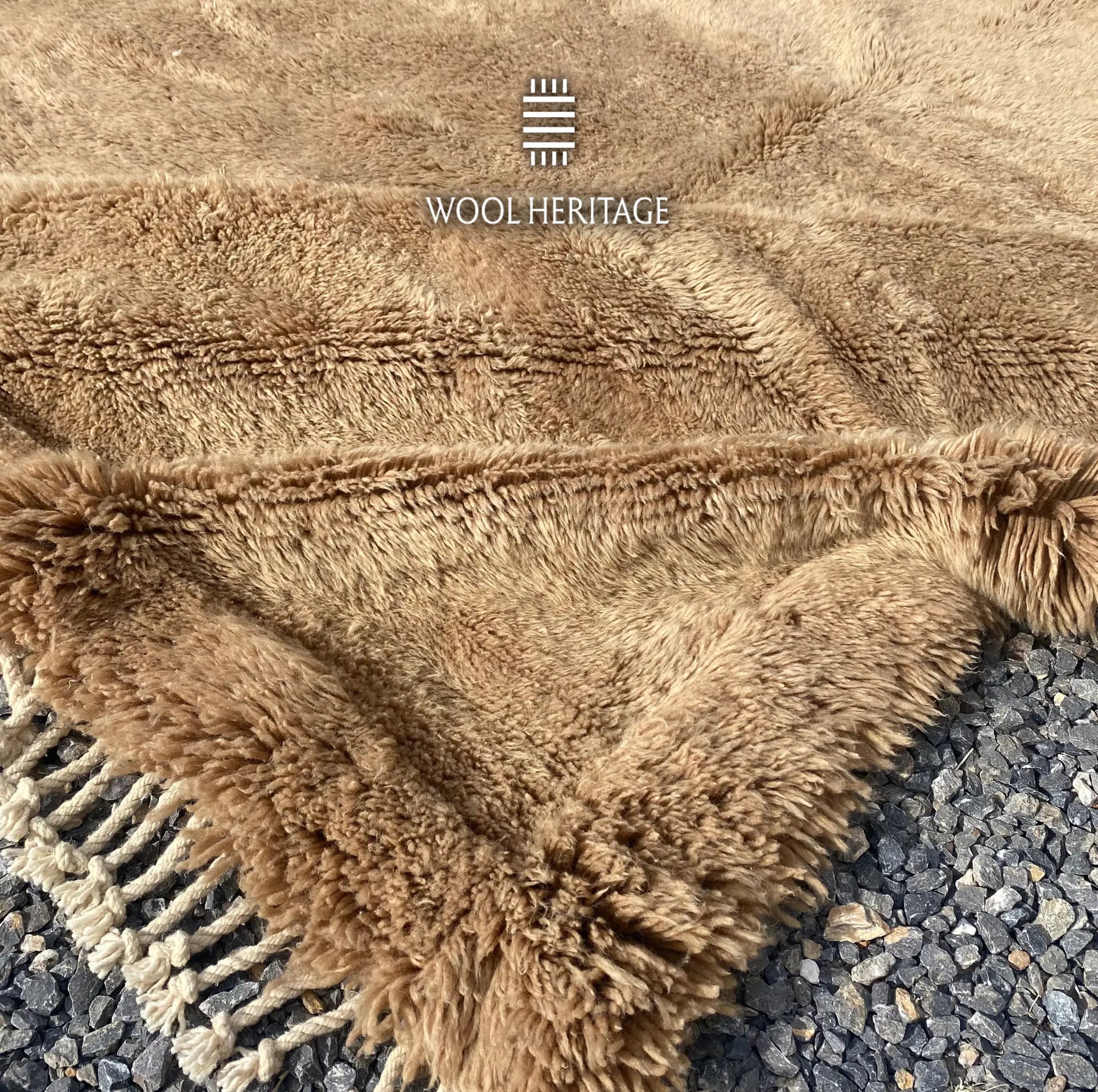 Folded corner of ASIREM hand-knotted Moroccan rug showing the woven back, border, and fringe finish