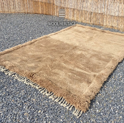 Angled view of ASIREM Beni Mrirt rug showing its minimal central line and textured border
