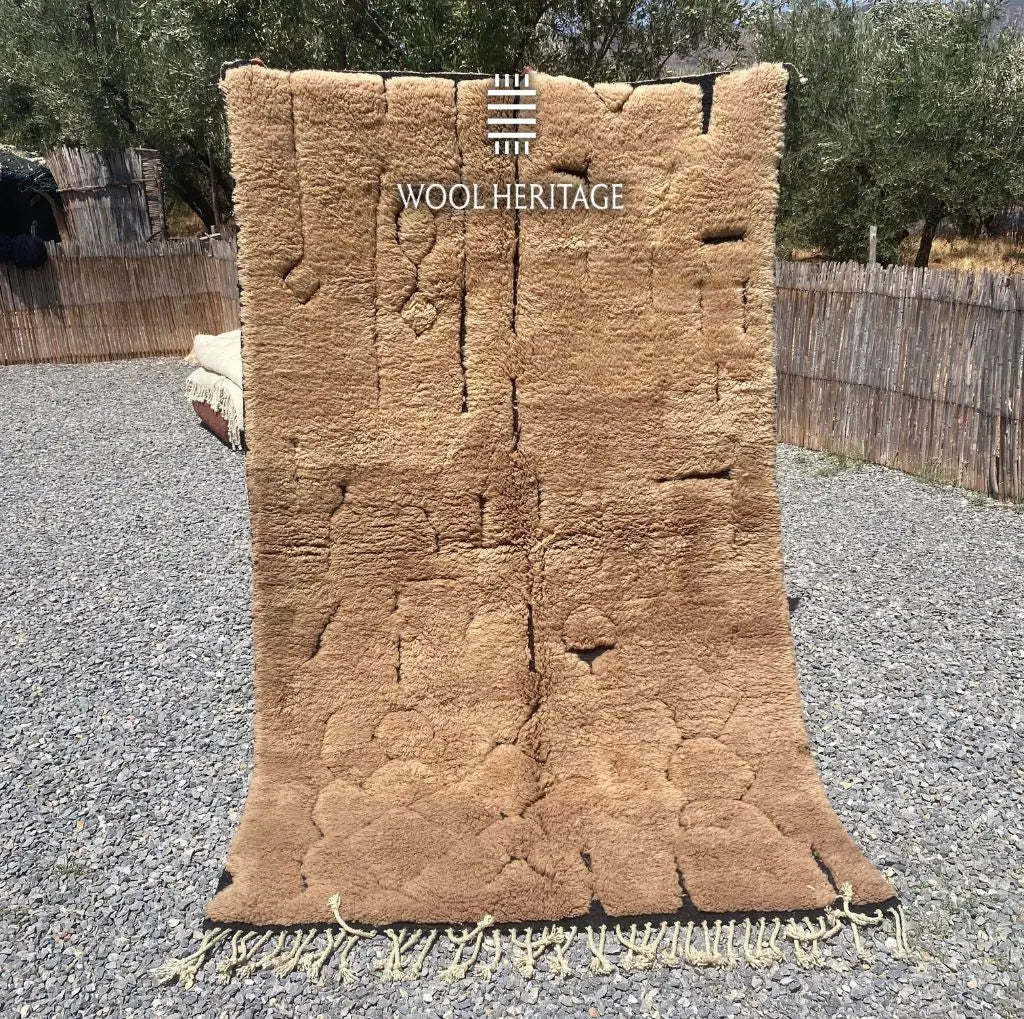 AZAGHAR camel-brown Moroccan wool rug shown upright outdoors with raised textured forms