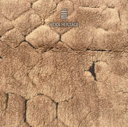 Close-up of AZAGHAR’s irregular pebble-like raised wool forms in camel brown
