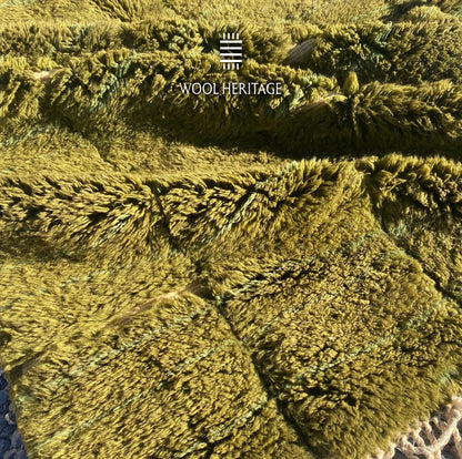 Detailed view of AZMMUR Moroccan wool rug showing its plush olive pile and recessed ivory channels