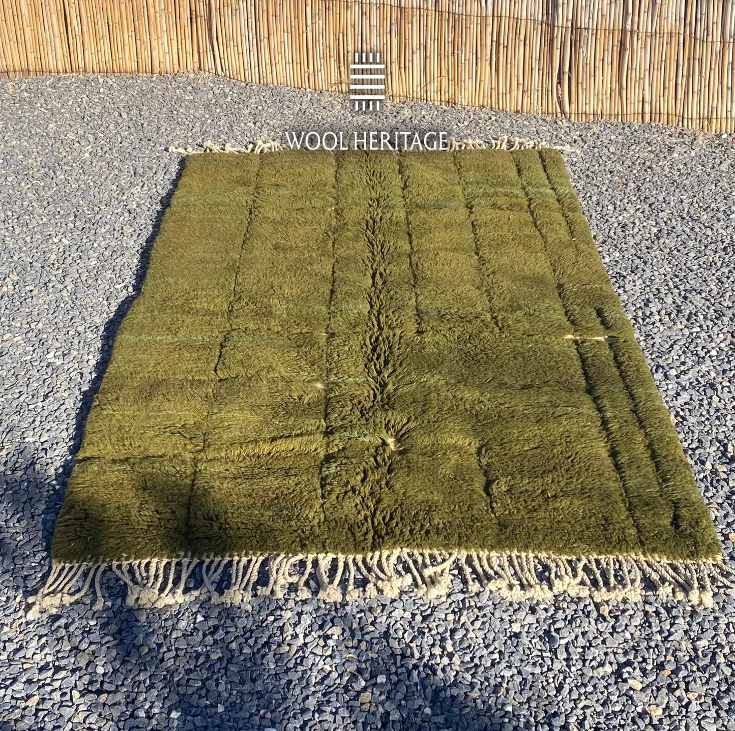 AZMMUR olive-green wool rug laid flat, showing its asymmetrical raised rectangular pattern