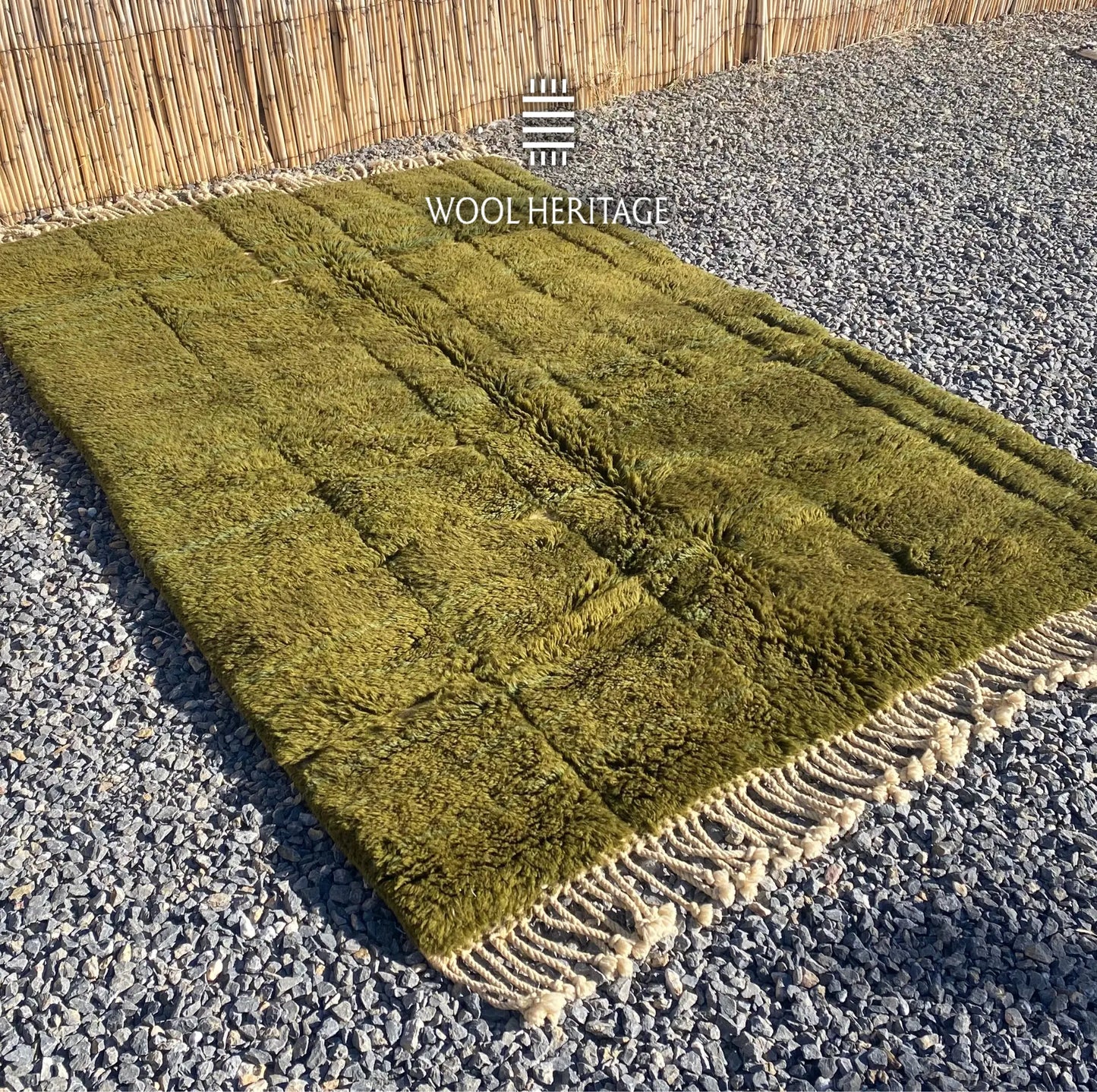 Angled view of AZMMUR Beni Mrirt rug showing its olive pile, ivory channels, and cotton fringe