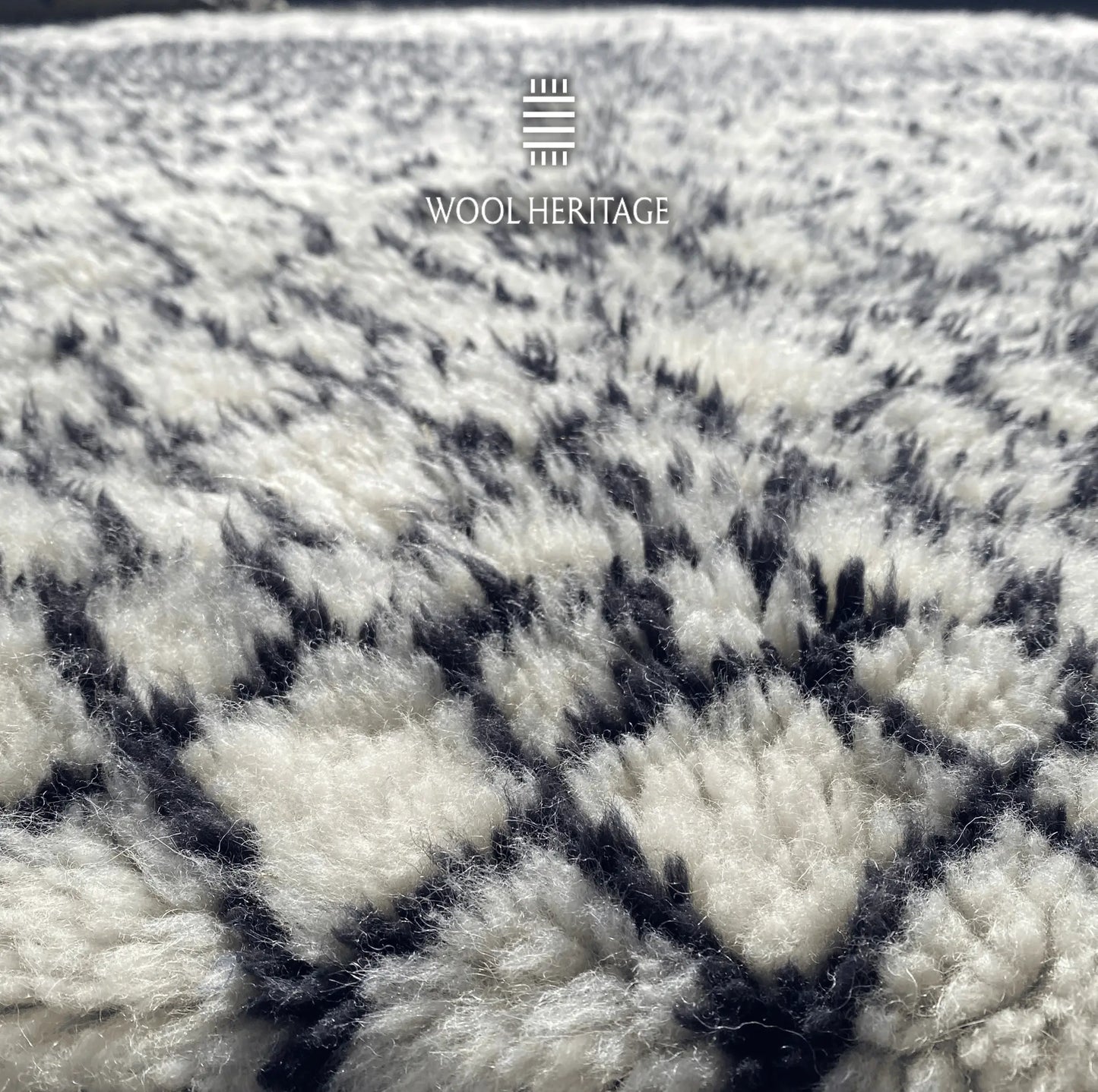 Close-up of ITRAN Moroccan rug showing its plush ivory wool pile and hand-knotted black lines