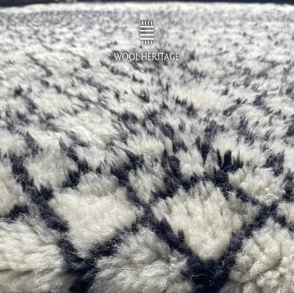 Close-up of ITRAN Moroccan rug showing its plush ivory wool pile and hand-knotted black lines