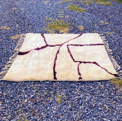 Full horizontal view of IZURAN Moroccan rug showing burgundy branches spreading across the warm ivory field