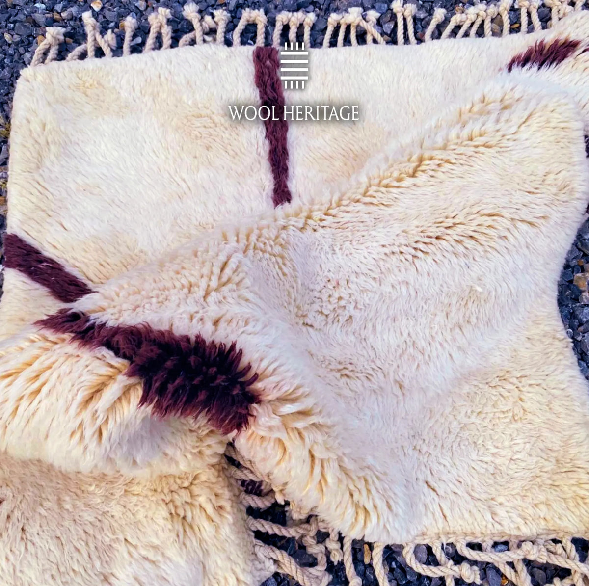 Folded texture detail of IZURAN rug showing deep burgundy branching lines against the soft ivory wool pile