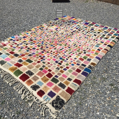 Angled view of TAFSUT Moroccan rug showing its colourful woven squares, soft pile, and hand-finished fringe
