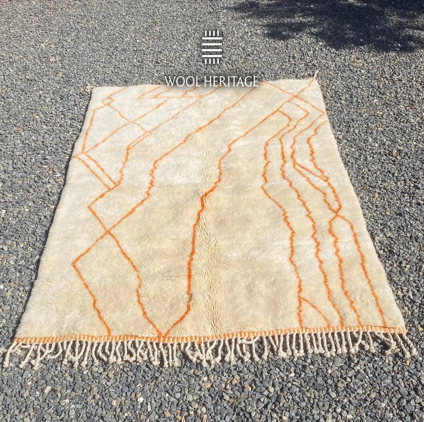 TAFUKT Beni Mrirt rug laid flat, showing its complete orange geometric composition across a warm ivory field