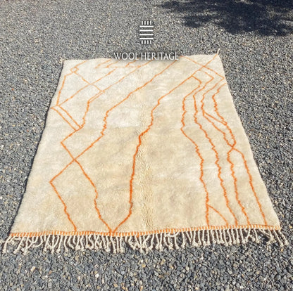 TAFUKT Beni Mrirt rug laid flat, showing its complete orange geometric composition across a warm ivory field