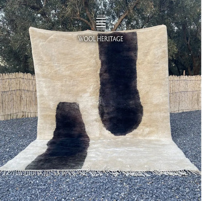 TAFUNAST hand-knotted black and ivory Moroccan wool rug displayed outdoors in a full front view with hand-finished fringe