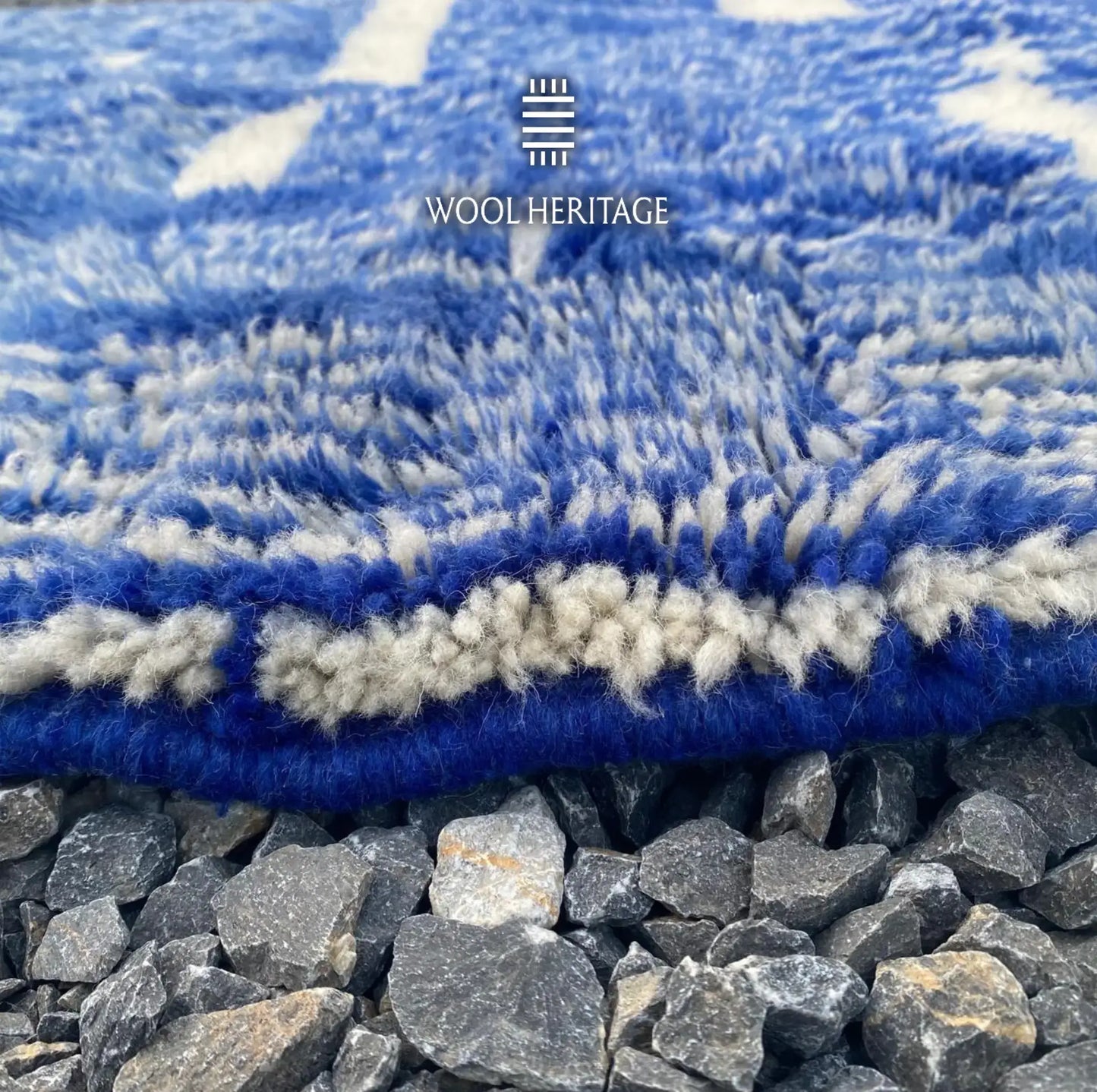 Close-up of TARGA rug showing its soft cobalt-blue and ivory wool pile with the finished edge