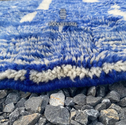 Close-up of TARGA rug showing its soft cobalt-blue and ivory wool pile with the finished edge