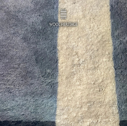 Detailed view of TAWWURT rug showing the ivory doorway passage framed by pale blue and deep navy wool