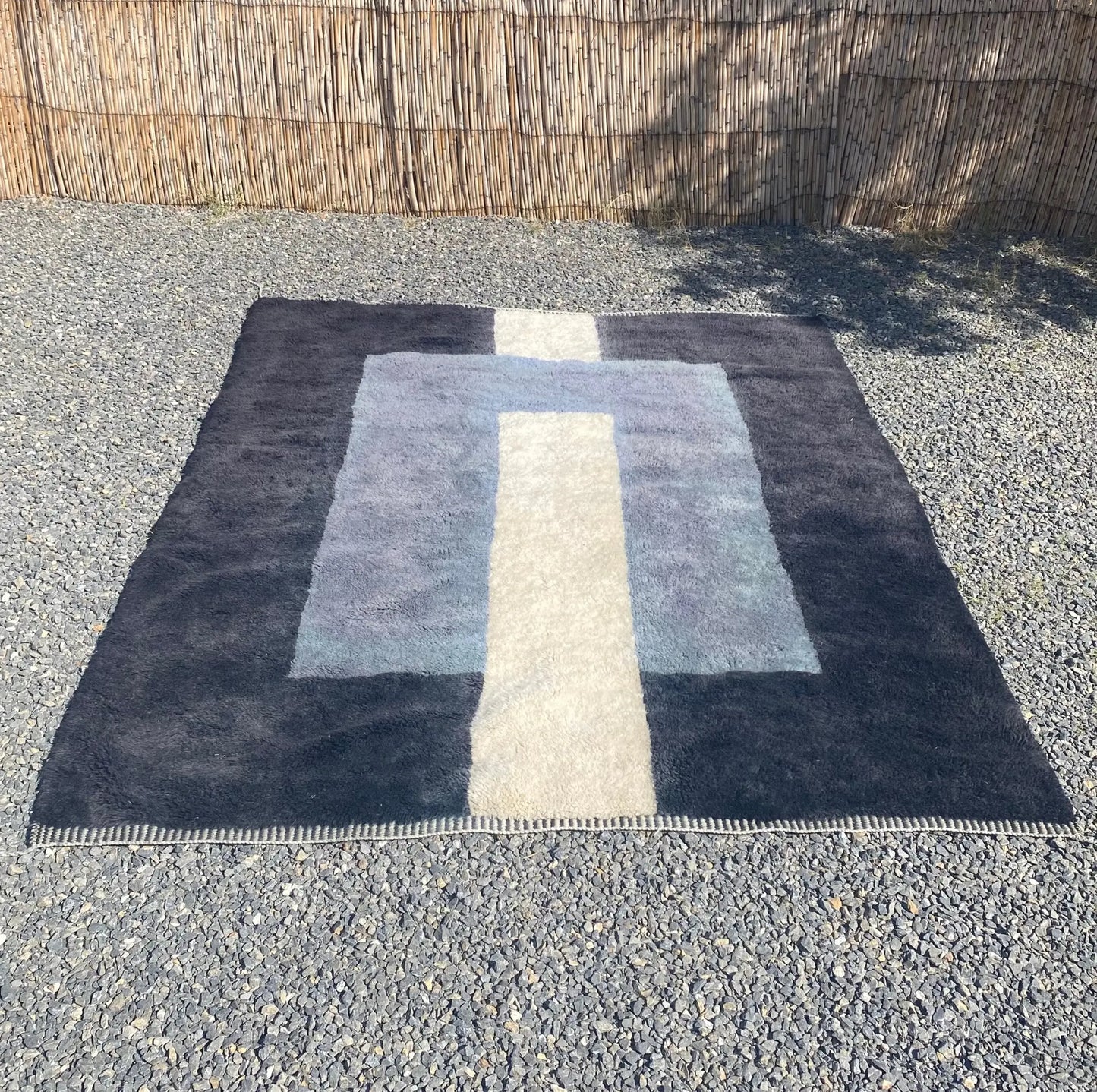 Lengthwise view of TAWWURT Moroccan rug showing the ivory path crossing layered navy and pale blue fields