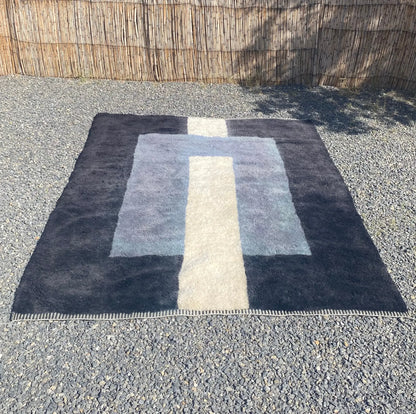 Lengthwise view of TAWWURT Moroccan rug showing the ivory path crossing layered navy and pale blue fields