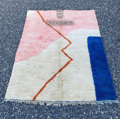 TAYRI Beni Mrirt rug laid flat, showing its pink, ivory, cobalt-blue, and terracotta geometric composition