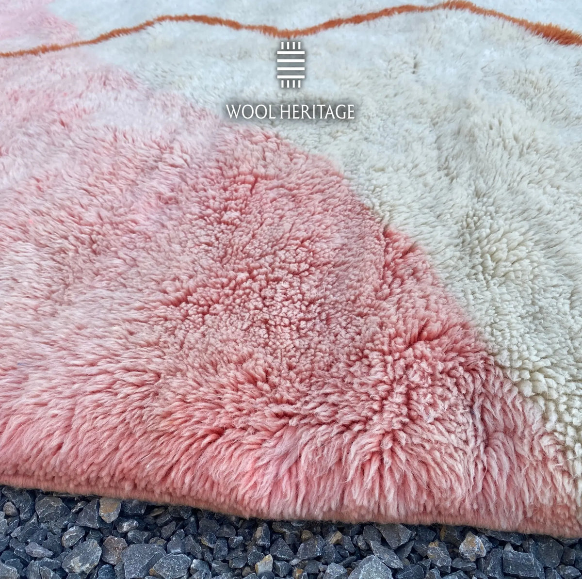 Close-up of TAYRI rug showing the soft pink wool pile, ivory section, and cobalt-blue colour block