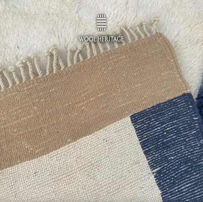 Back of TIFAWT hand-knotted Moroccan rug showing the woven ivory, beige, and navy colour-block construction