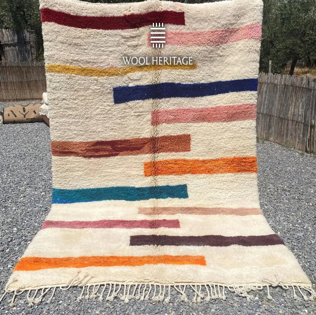 TIGRAT multicolour Moroccan wool rug shown upright outdoors with colourful horizontal bands