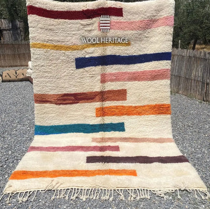 TIGRAT multicolour Moroccan wool rug shown upright outdoors with colourful horizontal bands