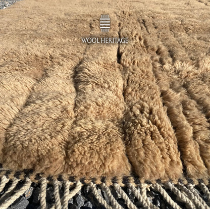 Detailed view of TIRRA Beni Mrirt rug showing the soft golden-brown pile and hand-plaited fringe