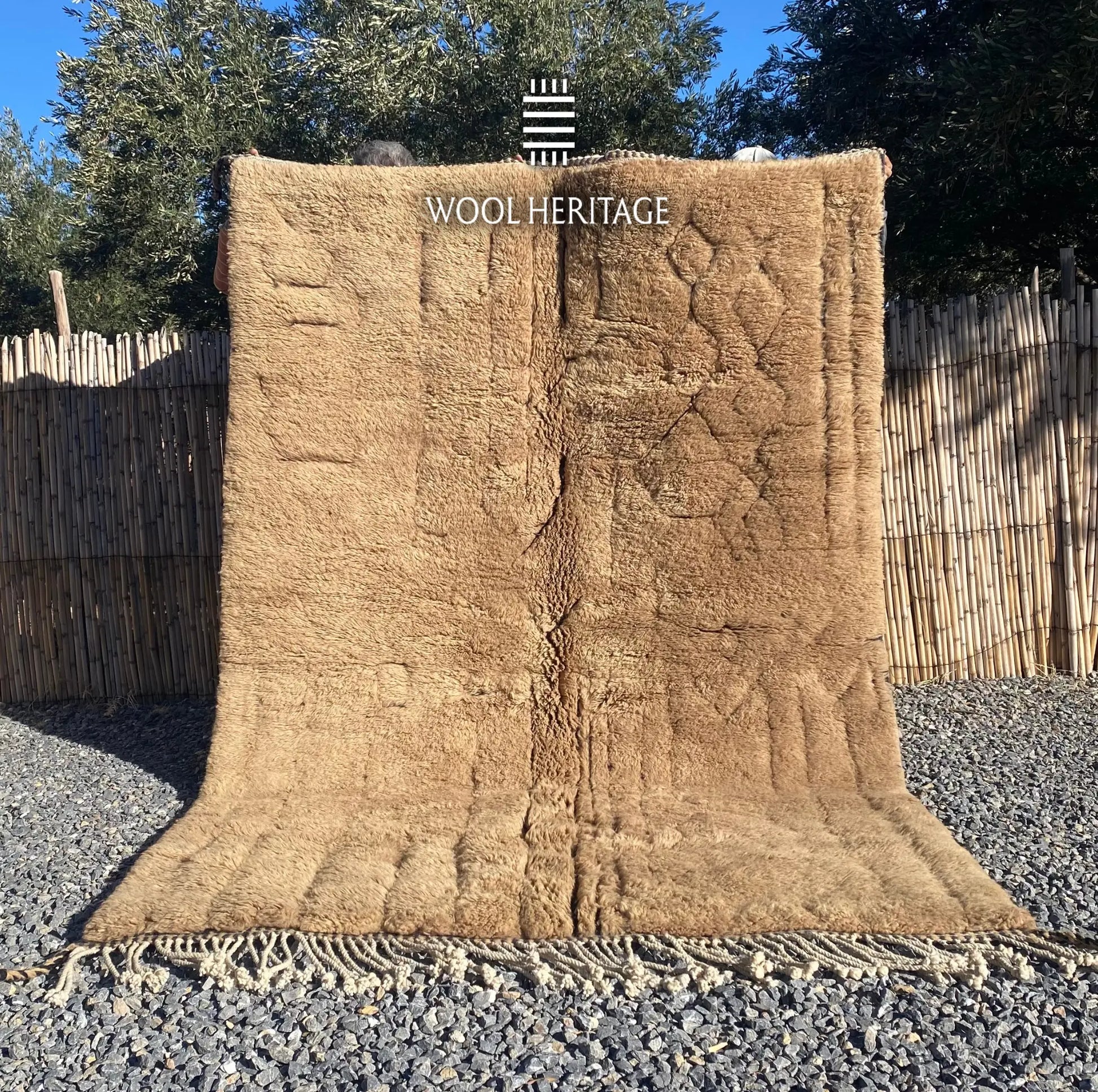 TIRRA hand-knotted golden-brown Moroccan wool rug displayed outdoors in a full front view