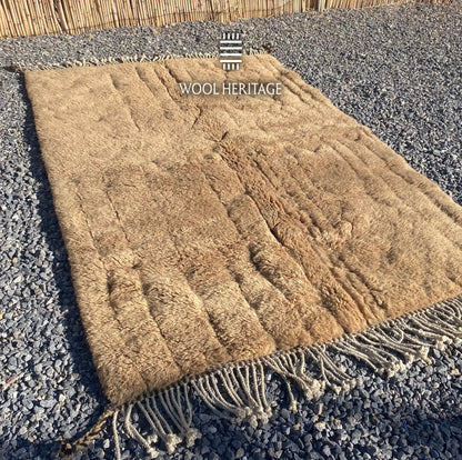 Angled view of TIRRA Beni Mrirt rug showing its sculpted markings, plush pile, and cotton fringe
