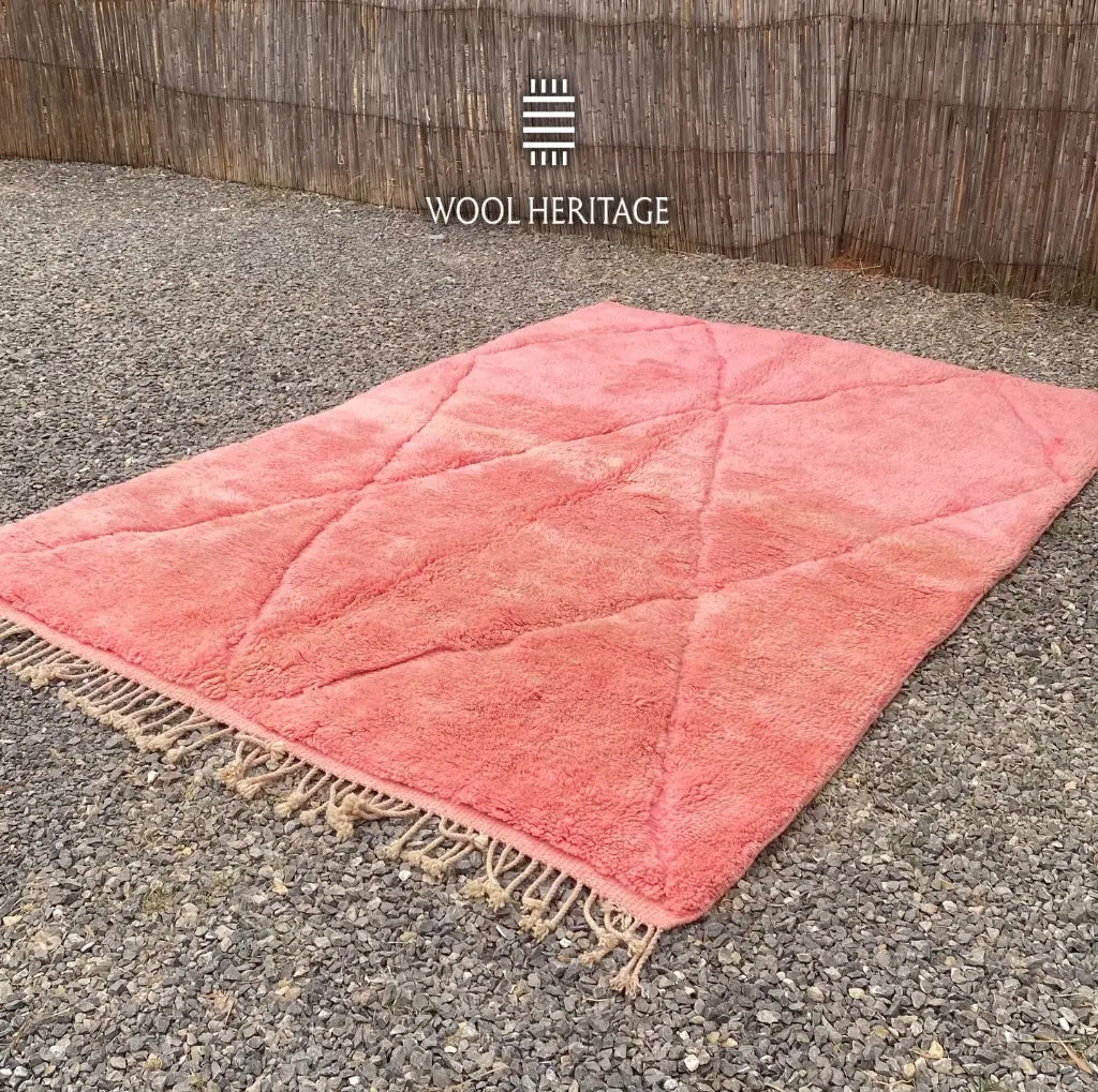 TISLIT coral-pink Beni Mrirt rug shown at an angle with raised geometric lines