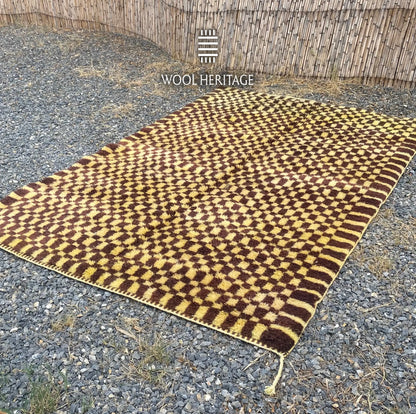 Angled view of TIZWIT Beni Mrirt rug showing its irregular golden-yellow and brown checkerboard
