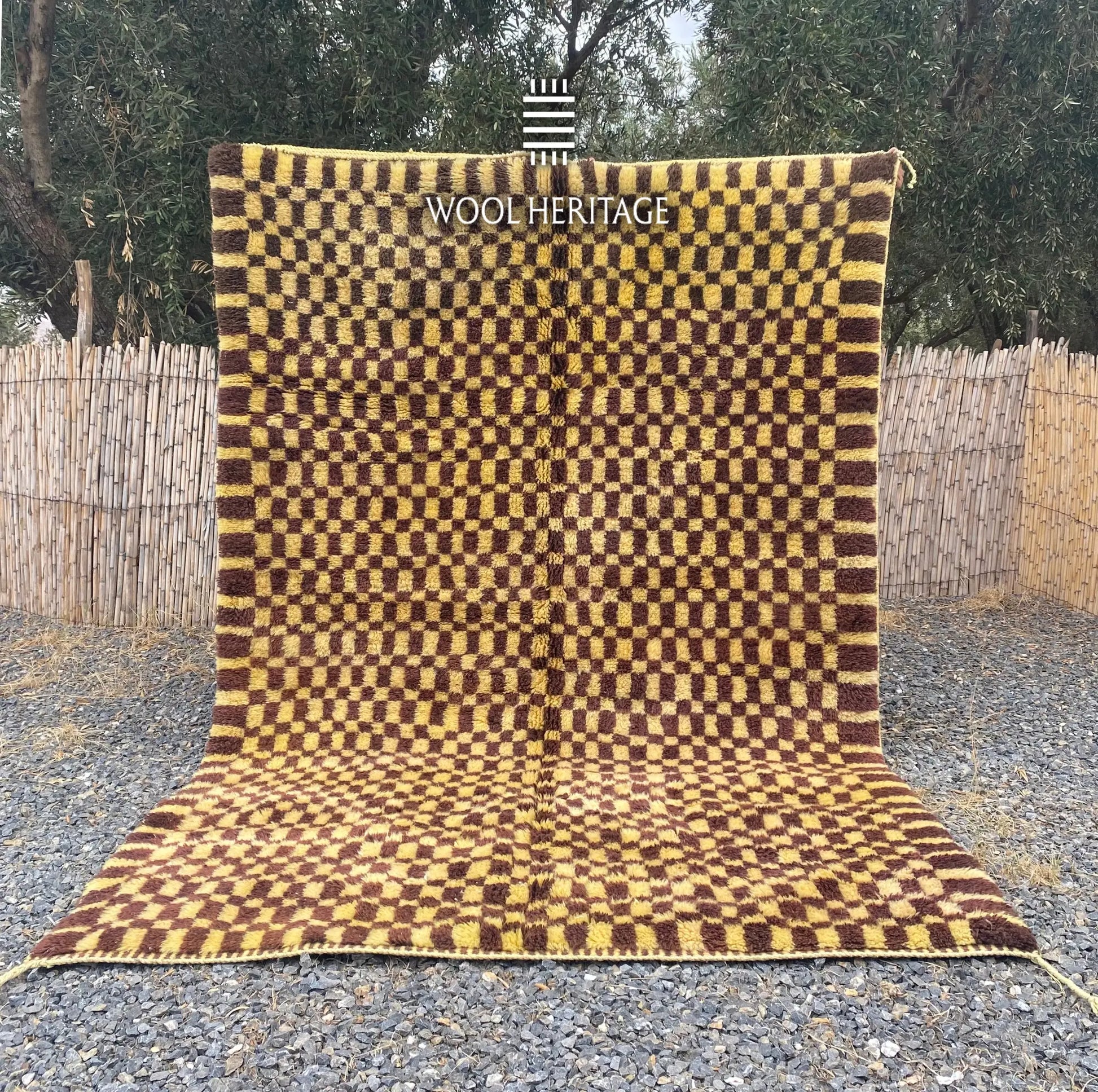 TIZWIT hand-knotted golden-yellow and brown Moroccan wool rug displayed outdoors in a full front view