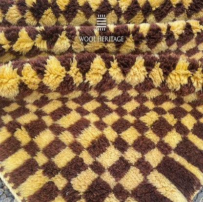 Detailed view of the TIZWIT rug edge showing its hand-knotted golden and brown wool texture