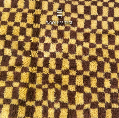 Close-up of TIZWIT Moroccan rug showing irregular golden-yellow and dark-brown wool squares