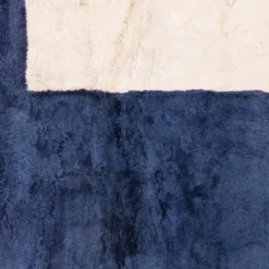 Handwoven blue abstract Moroccan area rug with indigo and white color blocks, made in natural wool by Beni Mrirt artisans.